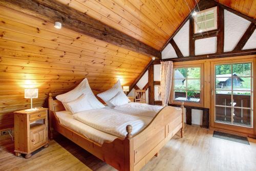a bedroom with a bed in a wooden cabin at Altes Zollhüsli in Schluchsee