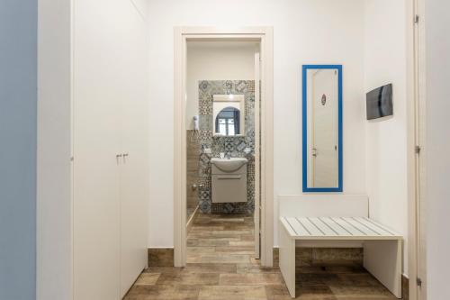 a white bathroom with a sink and a bench at Casavacanzefranca - 14 in Terrasini