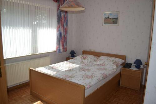 a bedroom with a bed in a room with a window at Ferienwohnung Meins in Friesoythe