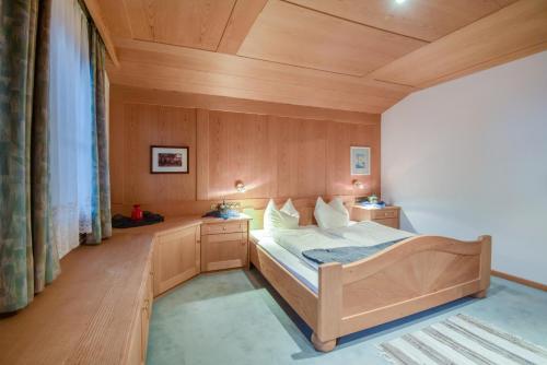 a bedroom with a bed and a wooden ceiling at Apartments Christa App A in Ortisei