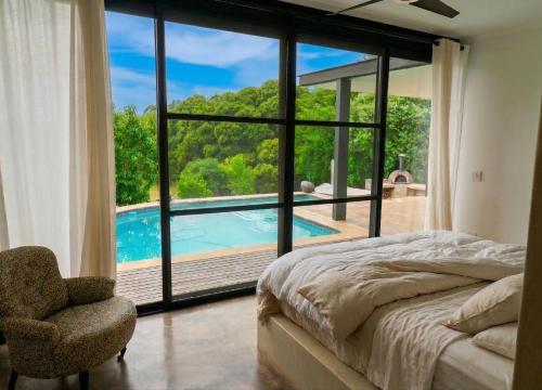a bedroom with a bed and a view of a pool at Cypiro Leopard Lodge in Kransberg