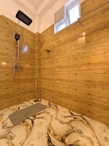 a room with a wooden wall with a large bed at Astral Zone Cottage Scenic Mountain view Stay Ella in Ella