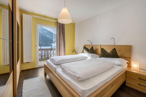 a bedroom with a large bed and a large window at Apartment Sciadules in Ortisei