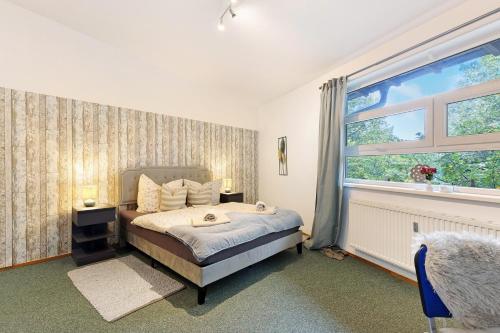 a bedroom with a bed and a large window at Albrechtshof Apartment 3 in Potsdam