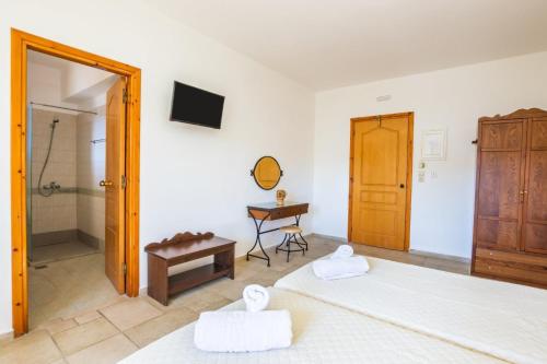 a bedroom with two beds and a shower at Petra Studios in Karpathos