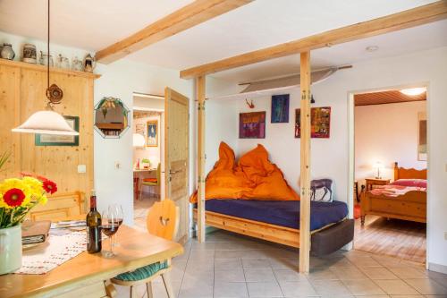 a bedroom with a bed with an orange comforter at Landhaus Lucia in Oberau