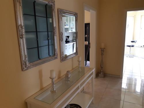a bathroom with a glass counter and a mirror at Ferienwohnung Laura in Langenargen