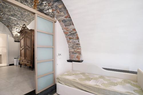 a bedroom with a bed and a brick wall at Inglese, borgo dei pescatori in Cervo