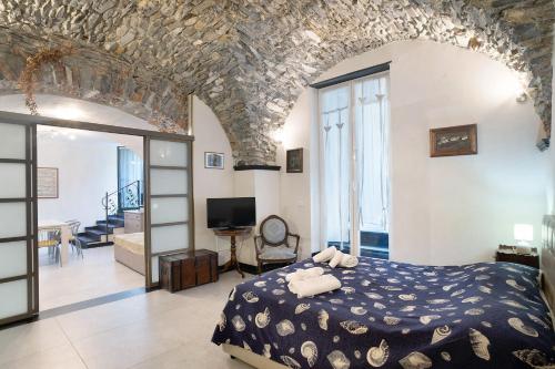 a bedroom with a large bed and a living room at Inglese, borgo dei pescatori in Cervo