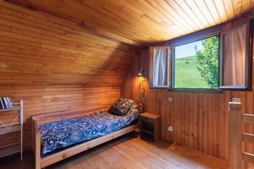 ein kleines Bett in einem Zimmer mit Fenster in der Unterkunft Gite Lieuj in Peyrouse