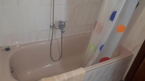 a bathroom with a bath tub with a shower curtain at Villa Consuelo in Cambrils
