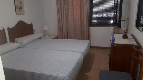 a bedroom with two beds and a desk and a window at Villa Consuelo in Cambrils