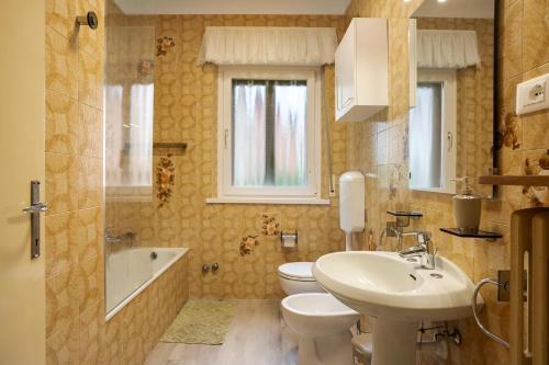 a bathroom with a sink and a toilet and a tub at Appartamento Marconi 35 Pergine in Pergine Valsugana