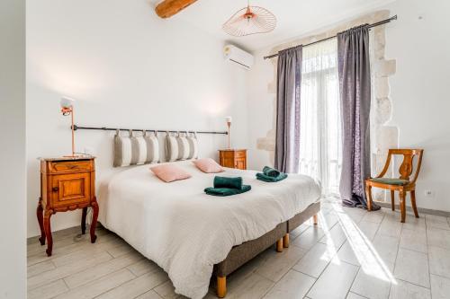 a bedroom with a large bed and a chair at Le Mas de Kitty - Maison d'hôtes in Saint-Rémy-de-Provence