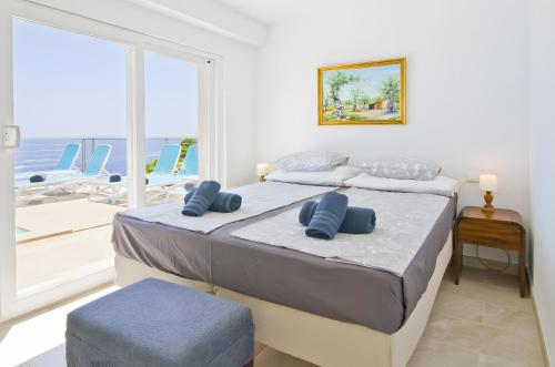 a bedroom with two beds and a large window at Villa Blanca in Capdepera