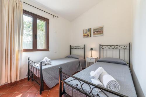 two twin beds in a bedroom with a window at Casa Mameli in Quartucciu