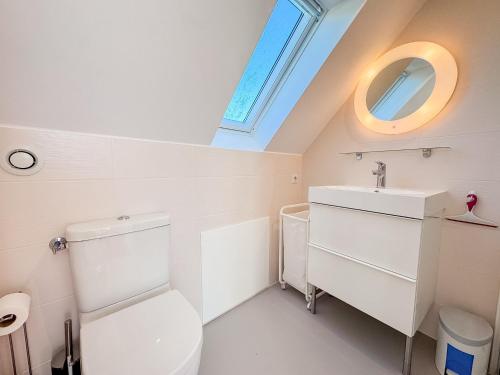 a bathroom with a toilet and a sink and a window at Les Embruns - Vue sur mer in Île-Tudy