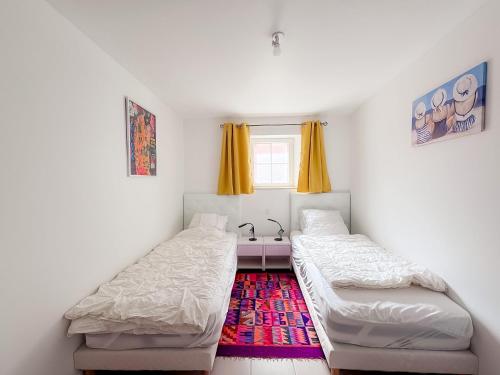 two beds in a room with a sink at Les Embruns - Vue sur mer in Île-Tudy