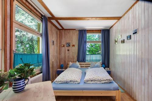 a bedroom with a bed and two windows at Ferienhaus beim Alenbrunnen in Münsingen