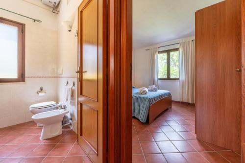 a bathroom with a toilet and a bed at Casa Mameli in Quartucciu
