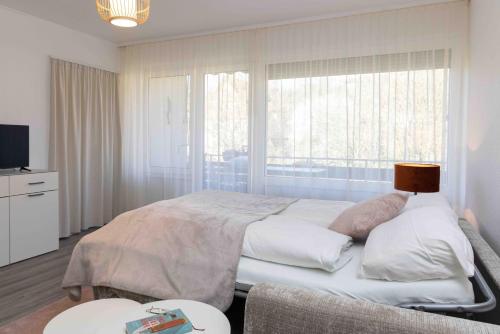 a bedroom with a large bed and a window at Herzlichstharz - Klein und Fein in Bad Lauterberg