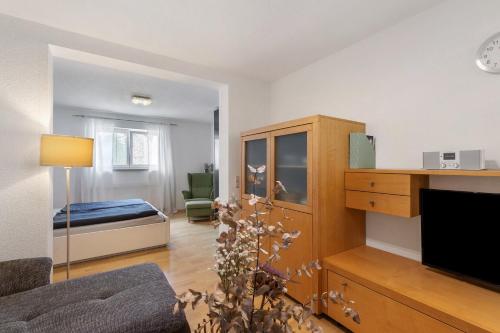 a living room with a bedroom with a bed and a tv at Ferienwohnung Emilia, 36qm in Münsingen