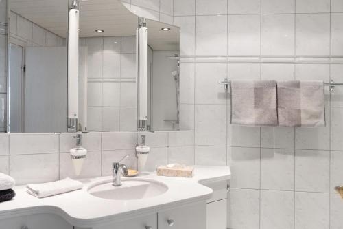 a white bathroom with a sink and a mirror at Ferienwohnung am Schlosssee in Salem
