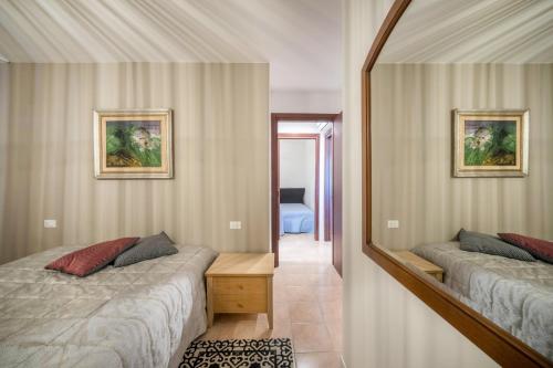 a bedroom with two beds and a mirror at La terrazza sul faro in Lignano Sabbiadoro
