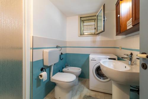 a bathroom with a toilet sink and a washing machine at Villa Bartolomeo in Modica