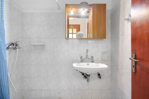 a bathroom with a sink and a mirror at Areti Orfeas Apartment 5 in Vasilikos