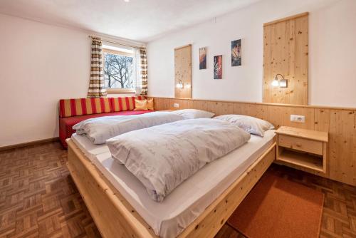 a bedroom with two beds and a red couch at Apartment Eisacktal in Mühlbach