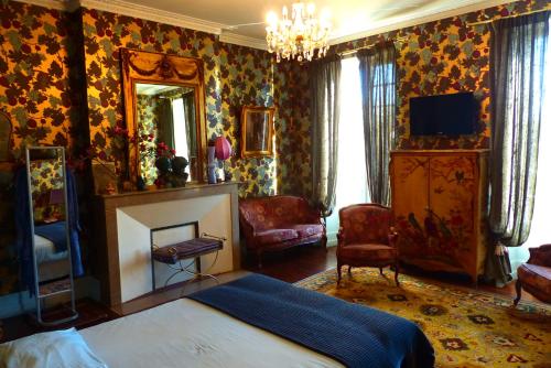 a bedroom with a bed and a fireplace and a mirror at La Rebière d'Or, B&B et Gîte in Mouleydier