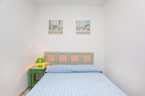 a bedroom with a bed and a night stand with a lamp at Villa Mula 1 in Orosei