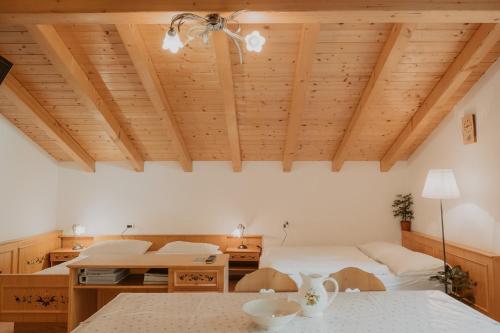 a bedroom with two beds and a wooden ceiling at Gogererhof App Maria in Racines