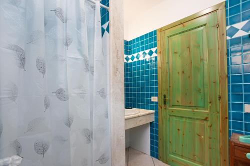 a bathroom with a green door and a sink at Villa Mula 1 in Orosei