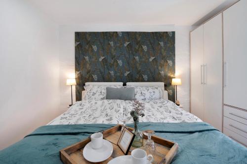a bedroom with a large bed with a wooden tray on it at Grünzweig in Dobeneck