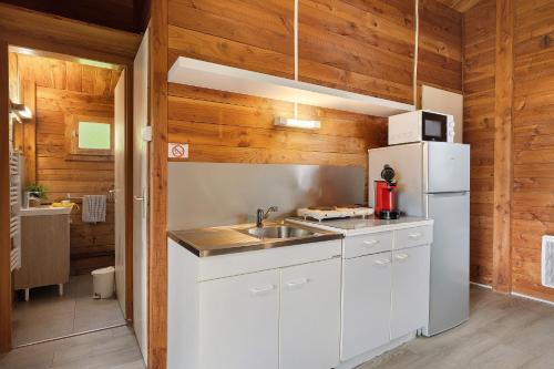 a kitchen with a white refrigerator and a sink at Chalet confort 21 in Saint-Gervais