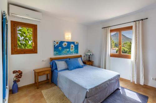 a bedroom with a blue bed and a window at S Estanyol in Colonia de Sant Pere
