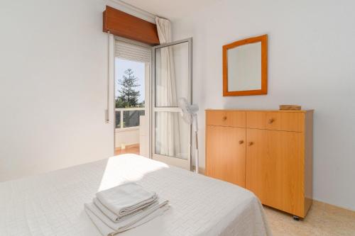 a white bedroom with a bed and a window at Beach and Pool Laguna Beach A113 in Torrox