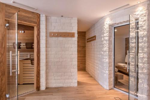 a bathroom with a glass door leading to a shower at Hotel Residence Gardena Dolomites in Santa Cristina Gherdëina