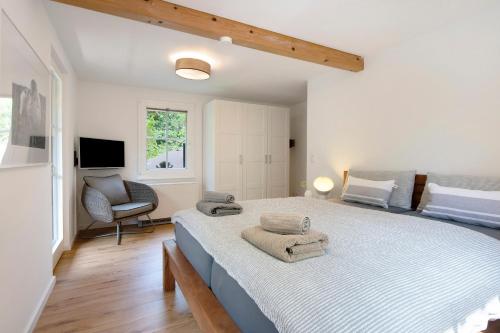 a bedroom with a large bed with towels on it at Gutenburghüsli mit Garten am Fluss in Weilheim