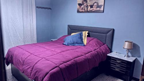 a bedroom with a bed with a purple comforter at Casa Johana in El Arenal