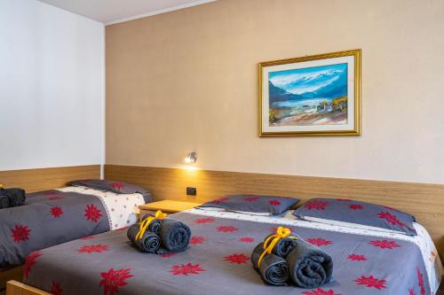a hotel room with two beds and a picture on the wall at Casa Mara in Predazzo