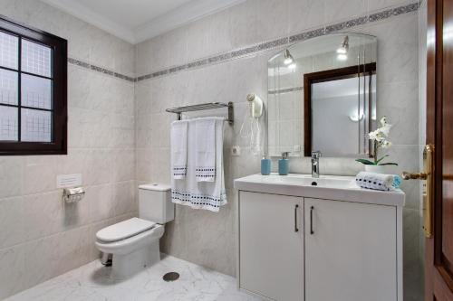 a bathroom with a toilet and a sink and a mirror at Casa Margarita in Lanzarote