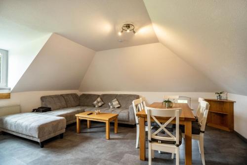 a living room with a couch and a table at Nordsee Ferienwohnung Möwe in Thunum