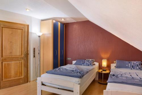 a bedroom with two beds and a staircase with a door at Haus Claudia in Fulda