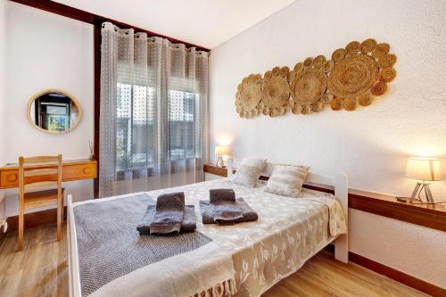 a bedroom with a bed with towels on it at Casa de Praia Tróia in Troia