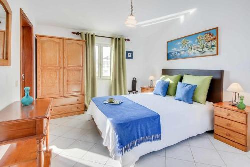 a bedroom with a large bed with blue and green pillows at Villa Brigida in Patroves
