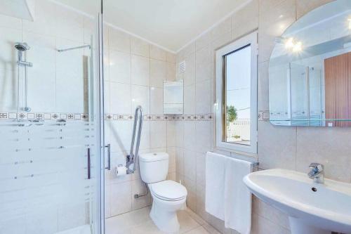 a white bathroom with a toilet and a sink at Villa Brigida in Patroves