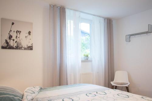 a bedroom with a bed and a window and a chair at Ferienwohnung Auszeit in Salem